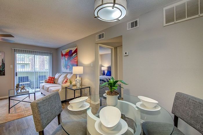 Chic and inviting living room with modern decor, featuring a cozy sofa, stylish dining area, and vibrant artwork.