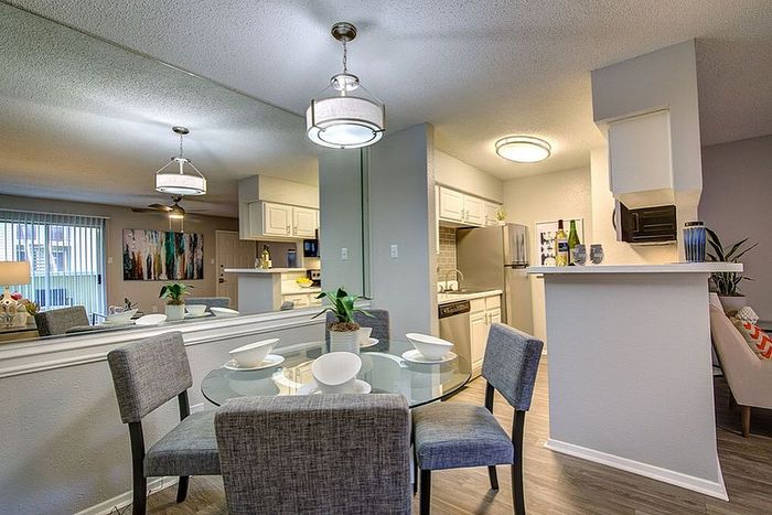 Chic open-concept apartment with modern kitchen and inviting dining area, featuring stylish decor and ample natural light.