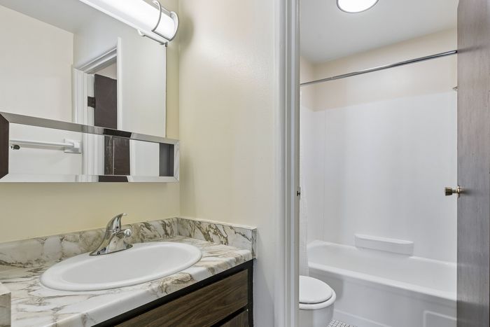 Bright and modern bathroom with elegant marble countertop and sleek fixtures.
