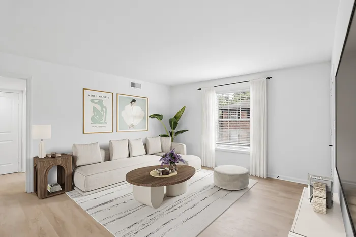 Bright and inviting living room with modern beige sofa and elegant decor, featuring artful wall accents and a cozy ambiance.