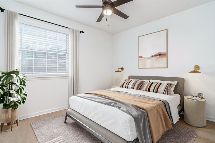 Inviting bedroom with modern decor, featuring a plush bed, stylish artwork, and a large window allowing natural light to fill the space.