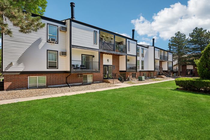 Charming apartment complex with modern design, featuring spacious balconies, lush green lawns, and a serene environment perfect for relaxation.