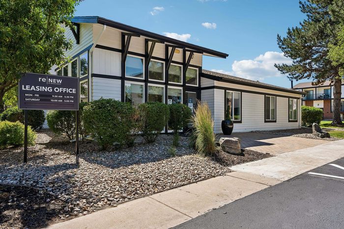 Bright and inviting leasing office surrounded by lush greenery and modern architecture, perfect for welcoming new residents.