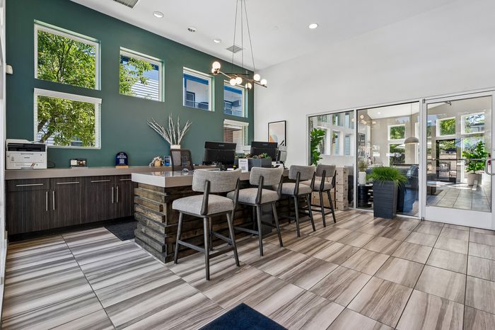 Modern and inviting apartment leasing office with stylish decor, natural light, and comfortable seating.