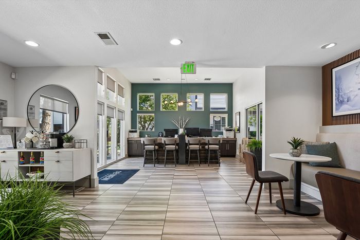 Inviting and modern office space featuring sleek furnishings, natural light from large windows, and stylish decor.