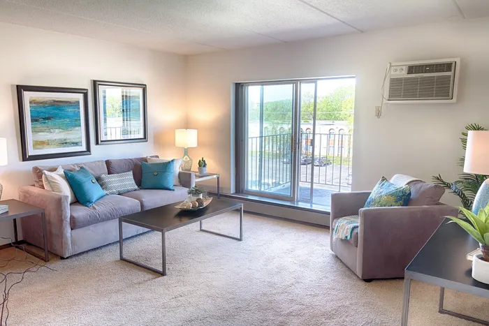 Inviting living room with cozy seating, modern decor, and a large window offering plenty of natural light.