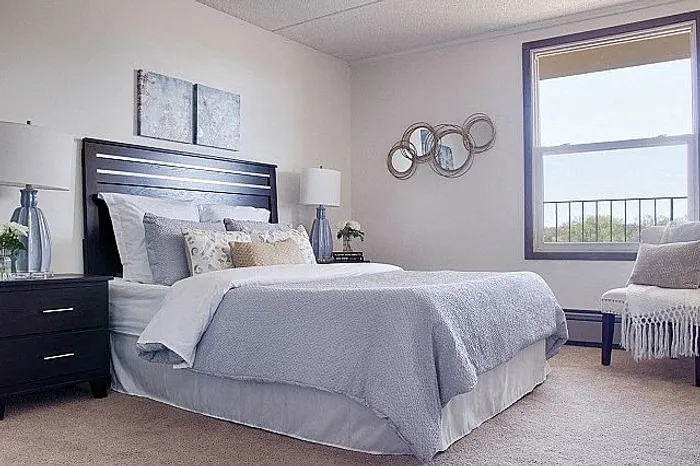 Bright and inviting bedroom with elegant decor, featuring cozy double bed, stylish nightstands, and a large window offering scenic views.