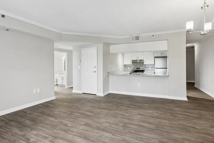 Modern open-concept apartment with sleek hardwood floors, stylish kitchen featuring granite countertops, and bright neutral interiors.