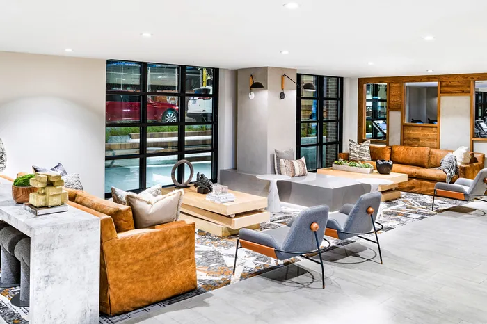 Modern, inviting lounge area with stylish leather sofas, elegant decor, and large windows offering natural light.