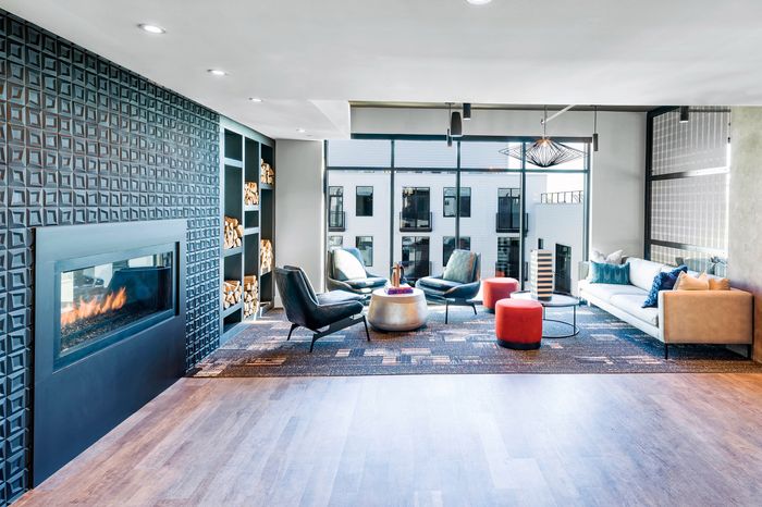 Modern lounge area with a cozy fireplace, sleek furniture, and large windows offering abundant natural light.