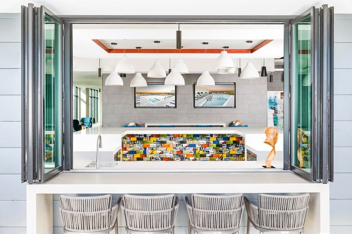 Contemporary kitchen with vibrant mosaic island, sleek white countertops, and modern pendant lighting, offering a stylish and inviting atmosphere.