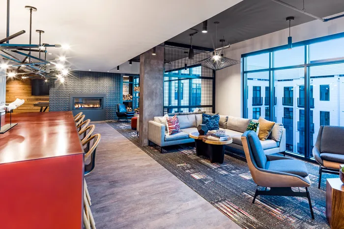Modern and inviting open-concept living area featuring sleek furniture, vibrant decor, and a cozy fireplace, perfect for relaxation and socializing.