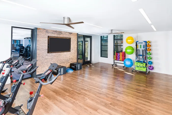 Bright and spacious gym area with sleek stationary bikes, diverse workout equipment, and modern design for an energizing fitness experience.