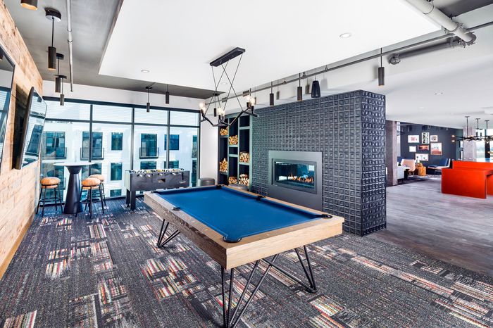 Chic entertainment room with sleek pool table, modern fireplace, and vibrant decor, perfect for social gatherings.