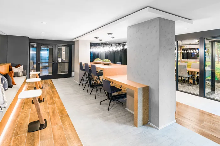 Contemporary lobby area with sleek wooden flooring, cozy seating, and modern lighting, ideal for relaxation and gatherings.