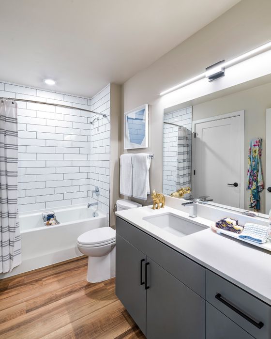 Modern bathroom design with elegant subway tile, sleek vanity, and stylish wood flooring.