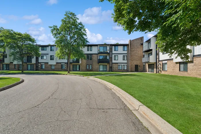 Charming apartment complex surrounded by lush greenery, showcasing modern architecture and tranquil outdoor spaces.