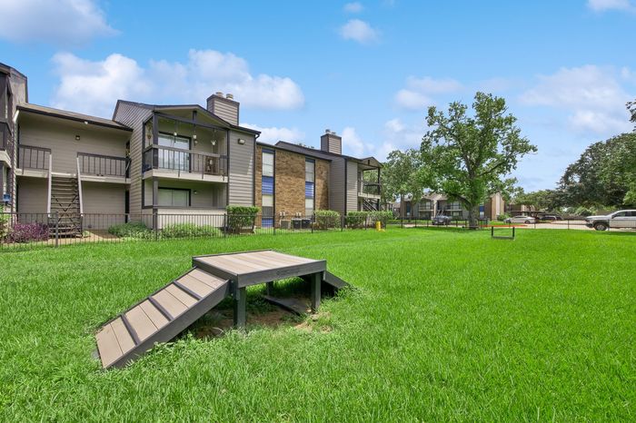Charming apartment complex surrounded by lush green lawns, featuring private balconies and a peaceful outdoor atmosphere.