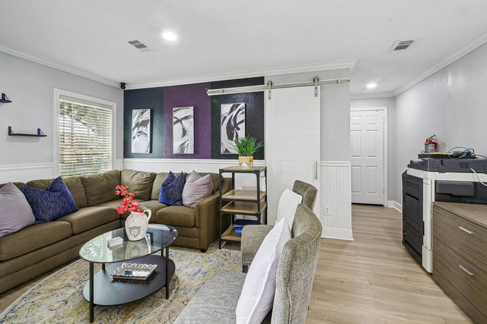 Inviting living room with a stylish sectional sofa, vibrant artwork, and elegant decor, perfect for relaxation and entertaining.