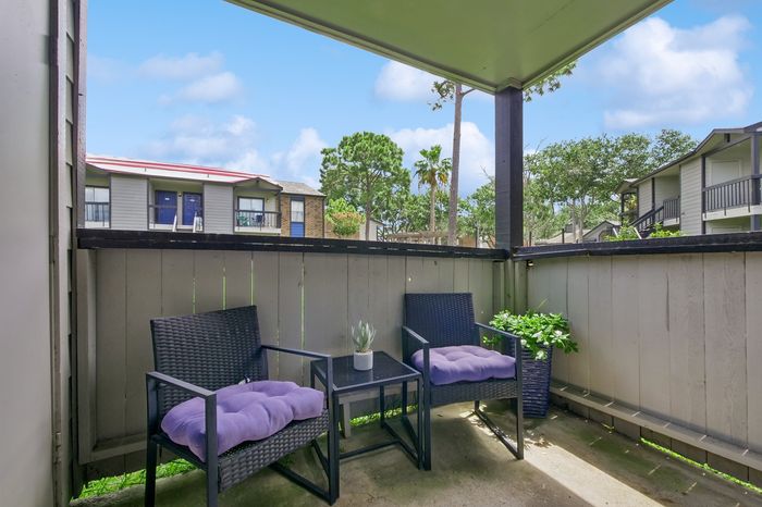 Cozy outdoor patio with comfortable seating and lush garden views, perfect for relaxing afternoons.