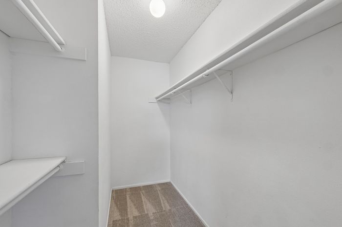 Spacious walk-in closet with ample shelving and hanging space, perfect for organized living.