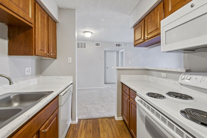Charming kitchen featuring warm wood cabinets, modern appliances, and a seamless transition to a cozy living space.