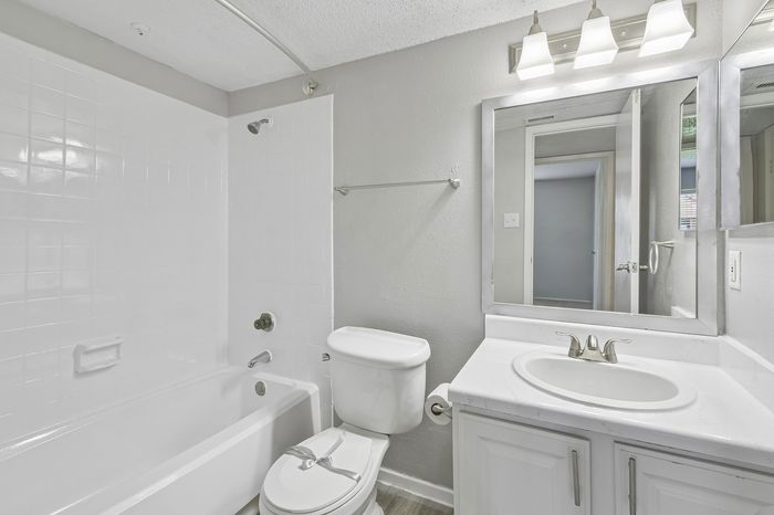 Bright and modern bathroom with elegant lighting, polished fixtures, and a sleek bathtub.