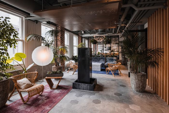 Chic urban lounge with elegant furniture, lush indoor plants, and modern architectural elements, perfect for relaxation.