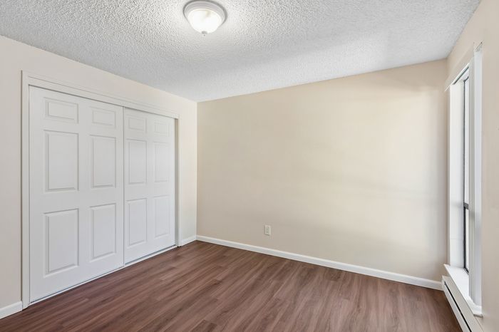 Bright room with elegant hardwood floors, large closet, and natural light streaming through the window.