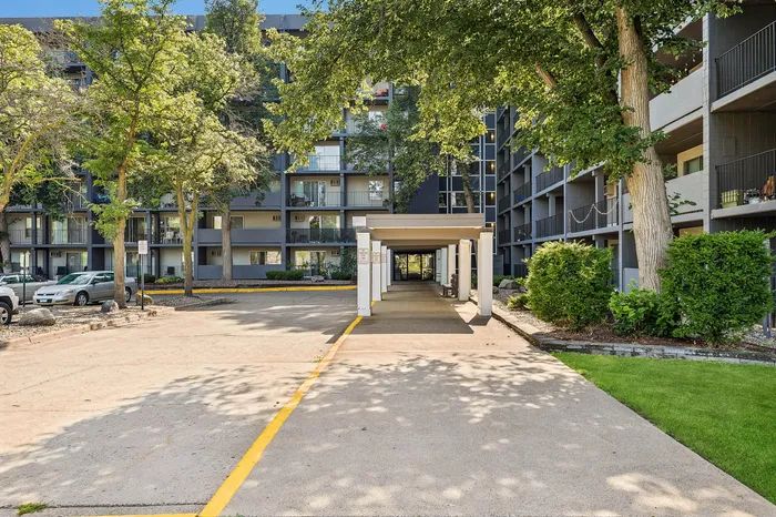 Charming apartment complex nestled among lush green trees featuring spacious balconies and modern exterior design.
