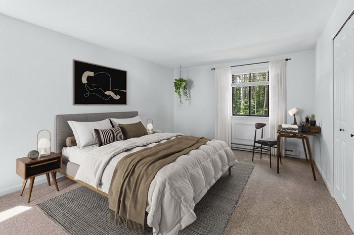 Inviting bedroom showcasing a plush bed with cozy accents, stylish decor, and a serene view through a large window.