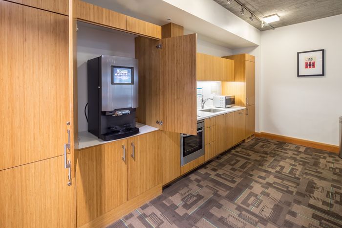 Modern kitchen with sleek wood cabinetry, built-in appliances, and stylish coffee machine, perfect for a contemporary home setting.