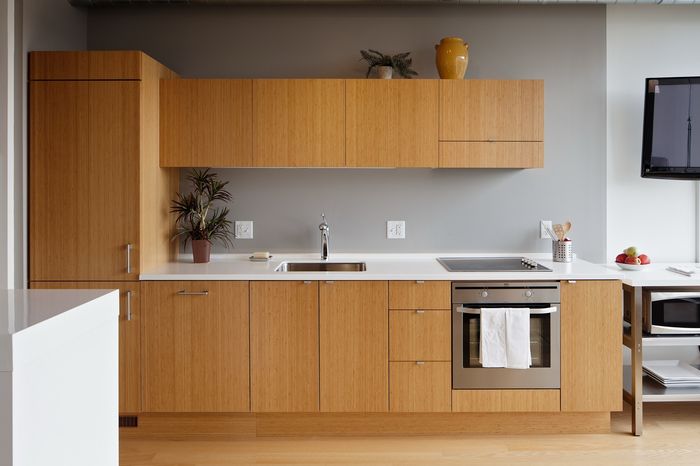 Modern kitchen with sleek bamboo cabinetry, integrated oven, and stylish decor, offering a contemporary aesthetic.