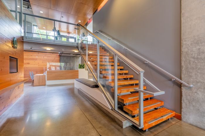Modern apartment lobby featuring sleek wooden staircase, stylish reception area, and contemporary design elements.