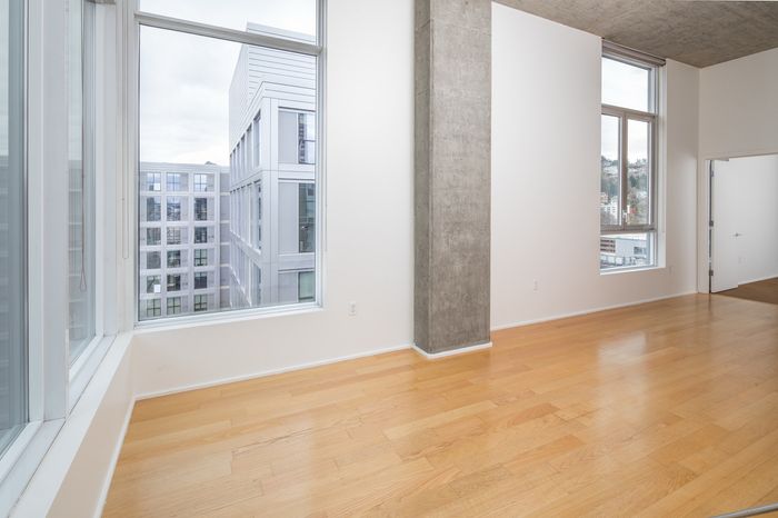 Bright modern apartment with hardwood floors and large windows offering city views.