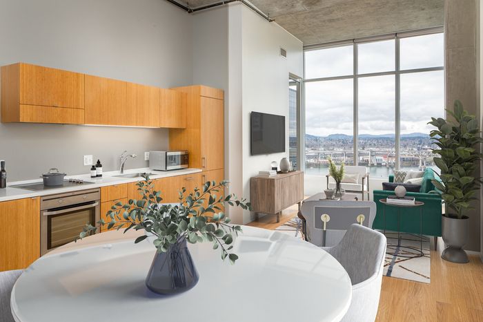 Modern apartment with open kitchen, cozy living area, and stunning floor-to-ceiling windows overlooking scenic views.