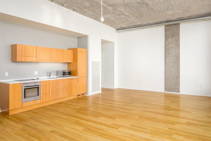 Bright open-concept kitchen with sleek wooden cabinets, modern appliances, and spacious hardwood flooring.