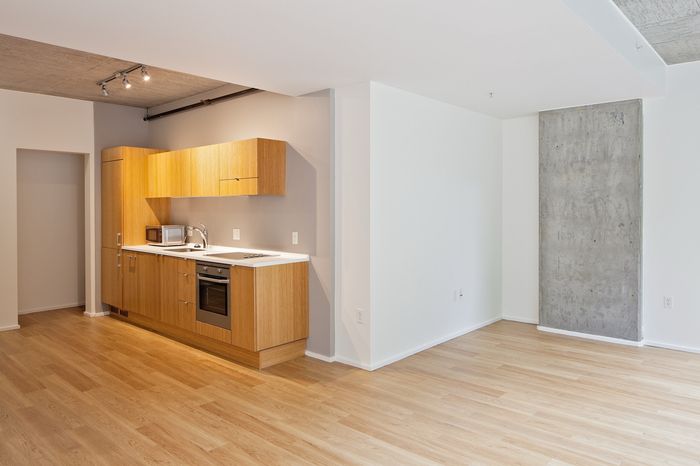 Modern open-plan kitchen with sleek wooden cabinetry and bright natural lighting, perfect for contemporary living.