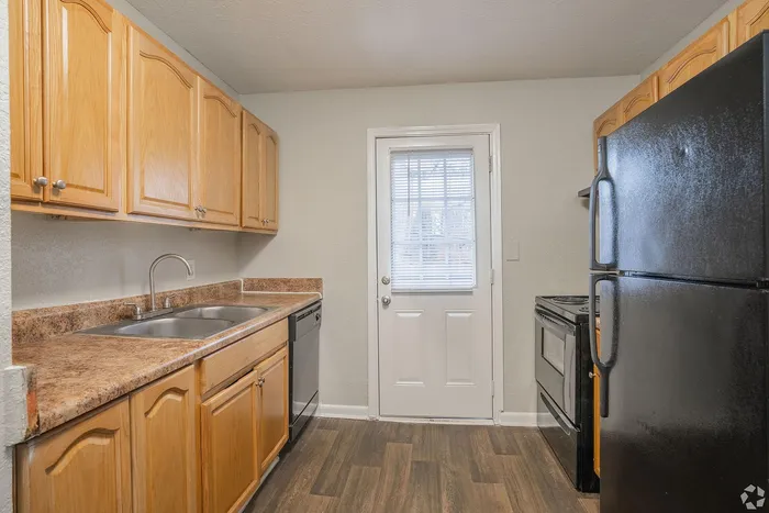 Charming kitchen with modern appliances, natural wood cabinetry, and sleek countertops, perfect for culinary enthusiasts.