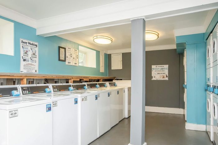 Bright and inviting laundry room featuring modern washing machines and stylish blue accents, ensuring a convenient and pleasant laundry experience.