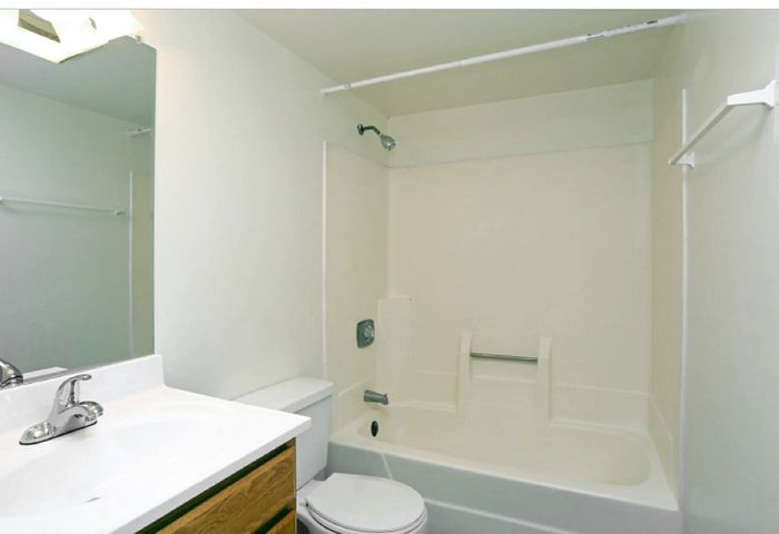 Bright and clean bathroom featuring a modern white bathtub, sleek sink, and minimalist design.