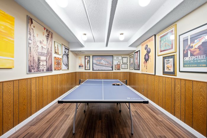 Chic and inviting recreation room with a ping pong table and eclectic art-covered walls, perfect for entertaining and relaxation.