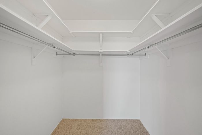 Spacious walk-in closet with ample shelving and hanging space, perfect for organizing a stylish wardrobe.