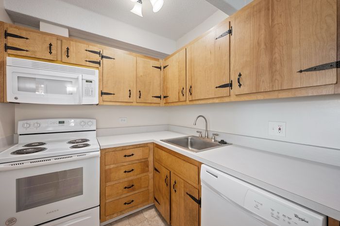 Charming kitchen with rustic wooden cabinetry, modern appliances, and a sleek countertop, perfect for cooking enthusiasts.
