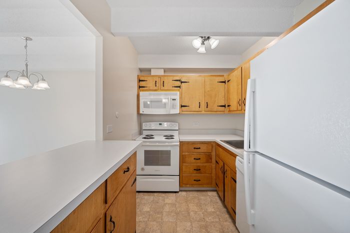 Inviting kitchen with warm wooden cabinets, modern appliances, and ample counter space for culinary creations.