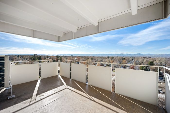 Expansive balcony with stunning panoramic views of lush landscape and distant mountains, perfect for outdoor relaxation.