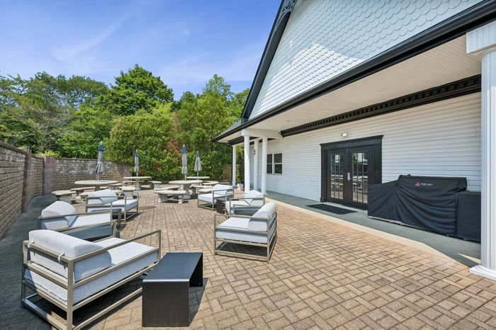 Inviting outdoor patio with stylish lounge seating, surrounded by lush greenery, perfect for relaxation and gatherings.