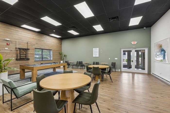 Inviting recreational room featuring a chic pool table, modern seating, and stylish wooden accents for a perfect social setting.