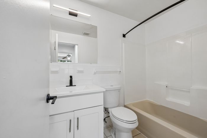 Bright and modern bathroom featuring a sleek vanity, contemporary fixtures, and a soothing bathtub design.
