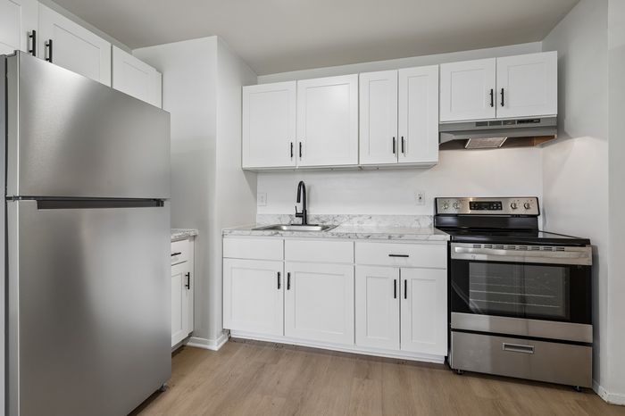 Modern kitchen with sleek stainless steel appliances, stylish white cabinetry, and elegant marble countertops.